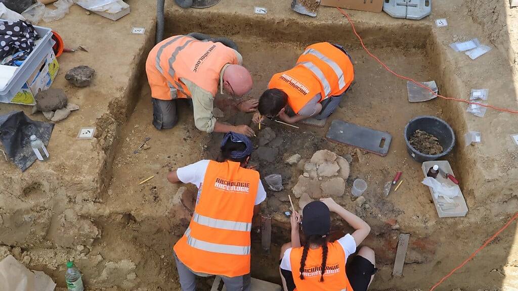 Die Archäologinnen und Archäologen dokumentieren und sichern die Fundstelle in Delley FR.