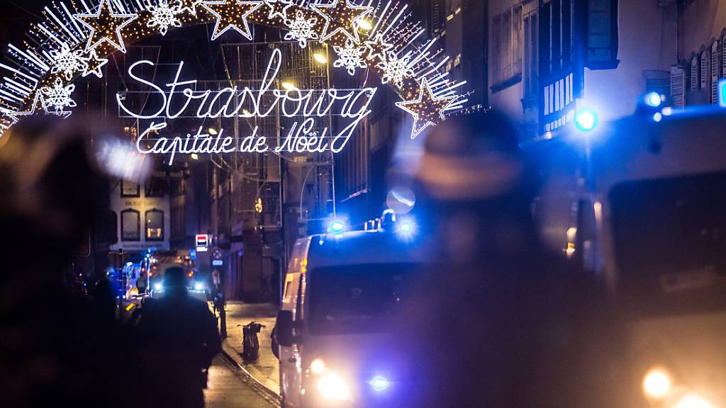 ARCHIV - Einsatzkräfte der Polizei sichern nach einem Angriff in der Gegend des Straßburger Weihnachtsmarkts einen Eingang zur Altstadt und damit zum Weihnachtsmarkt. Im Prozess um den Terroranschlag beim Straßburger Weihnachtsmarkt hat ein Schwurgericht einen Helfer des Täters zu 30 Jahren Haft verurteilt. Mit der Beschaffung von Waffen habe der 42-jährige Hauptangeklagte dem Täter bei der Umsetzung seiner Terrorpläne geholfen, urteilte das Gericht in Paris am Donnerstagabend. Bei dem Anschlag waren 2018 fünf Menschen getötet und elf weitere verletzt worden. Foto: Christoph Schmidt/dpa