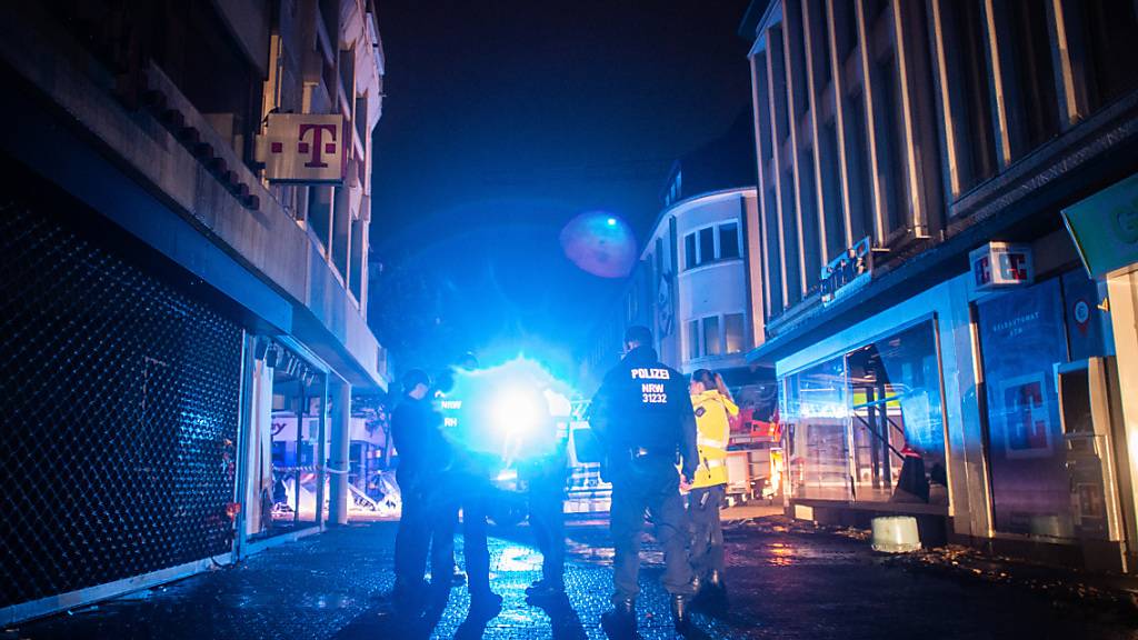 Polizisten gehen durch die zerstörte Innenstadt von Kirchheim in Nordrhein-Westfalen, um Plünderungen zu verhindern. Hier hatten heftige Regenfälle in der Nacht für Schlammlawinen und Überflutungen gesorgt. Kanzlerin Merkel hat den Betroffenen der Hochwasserkatastrophe rasche Hilfe versprochen. Foto: Jonas Güttler/dpa