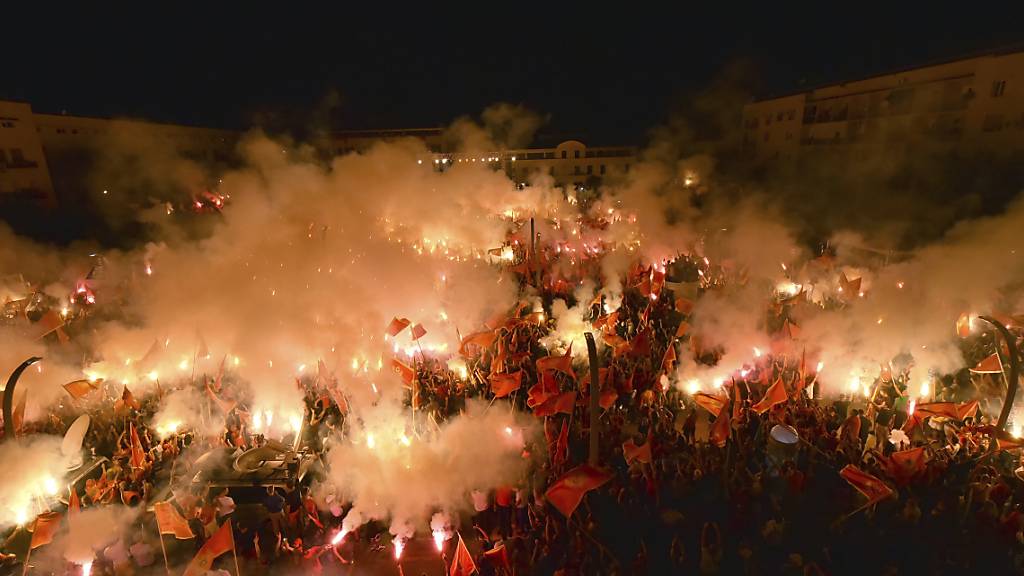 Eine Woche nach dem Wahlsieg der überwiegend pro-serbischen Opposition in Montenegro haben Zehntausende für den unabhängigen Staat protestiert. Demonstranten in der Hauptstadt Podgorica zündeten Fackeln an und schwenkten Nationalfahnen während einer Kundgebung. Foto: Risto Bozovic/AP/dpa
