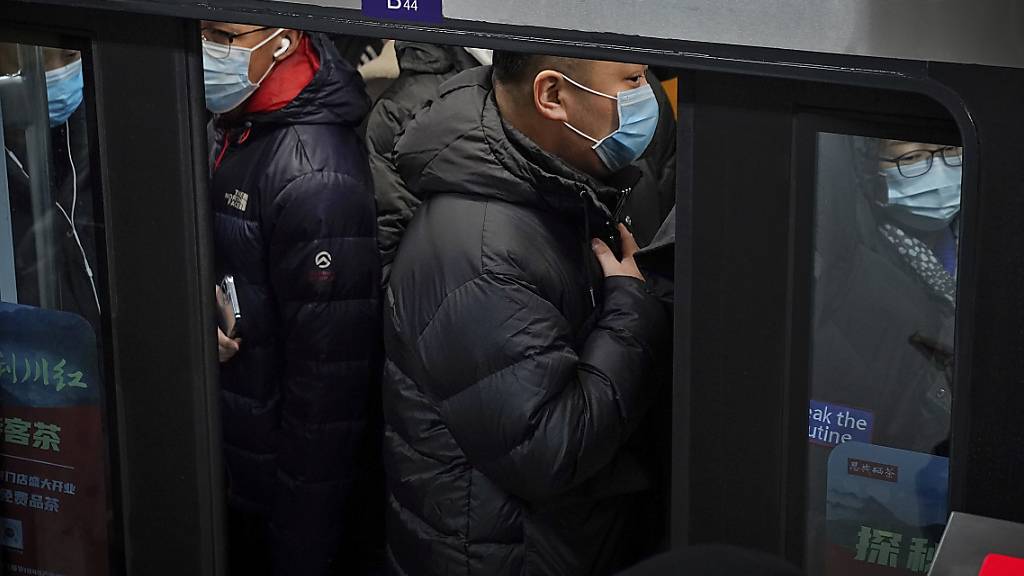 dpatopbilder - Pendler in Peking drängen sich in eine U-Bahn während der Hauptverkehrszeit. Foto: Andy Wong/AP/dpa