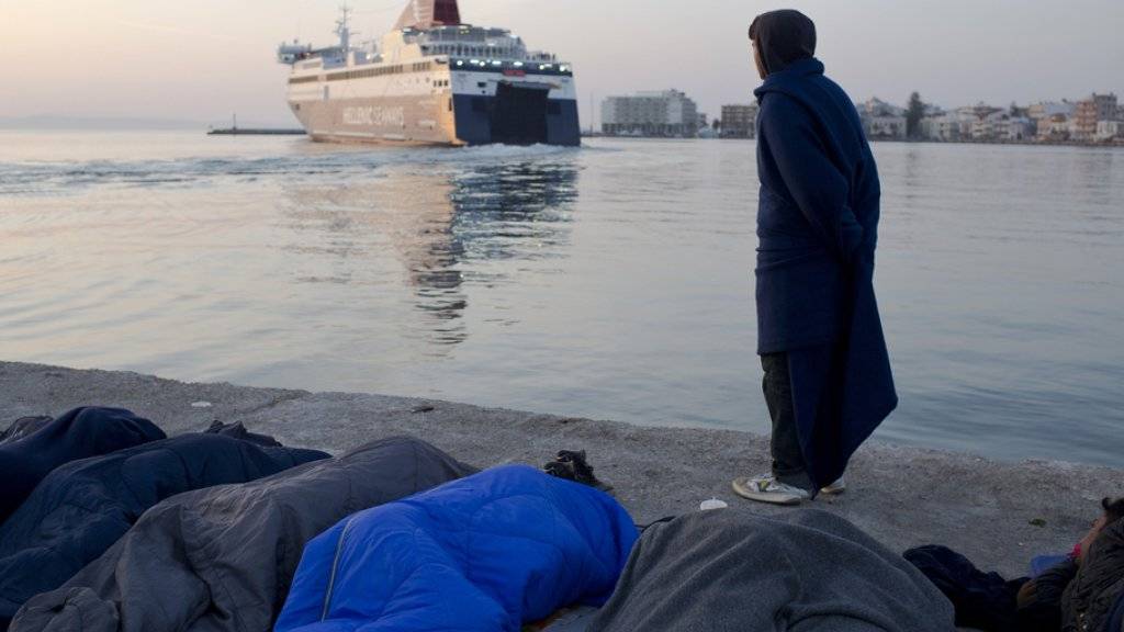 Ein pakistanischer Flüchtling schaut einer Fähre nach, die den Hafen der griechischen Insel Chios in Richtung Türkei verlässt. Nach dem Willen der EU-Kommission sollen die Flüchtlinge künftig besser in Europa verteilt werden. (Archiv)