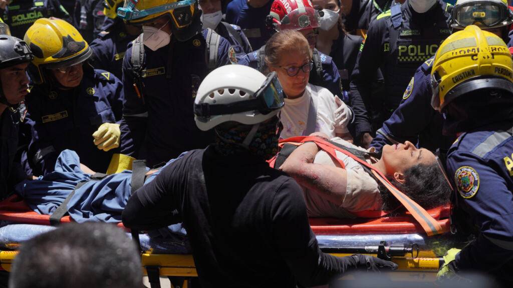 Rettungskräfte tragen Diana Troncoso, nachdem sie am Tag nach dem Erdbeben aus den Trümmern geborgen wurde. Foto: Ivan Valencia/AP/dpa