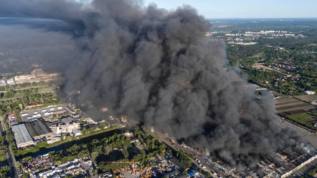 ARCHIV - Rauch steigt von einem großen Einkaufszentrum auf. Das Feuer brach am Sonntagmorgen aus. Foto: Norbert Ofmanski/AP/dpa
