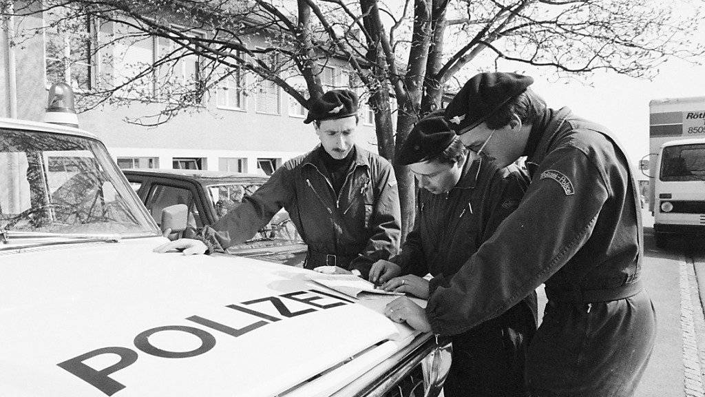 Polizisten besprechen sich zur Suche nach der verschwundenen Edith Trittenbass vor deren Schulhaus in Wolfikon. (Archivbild)