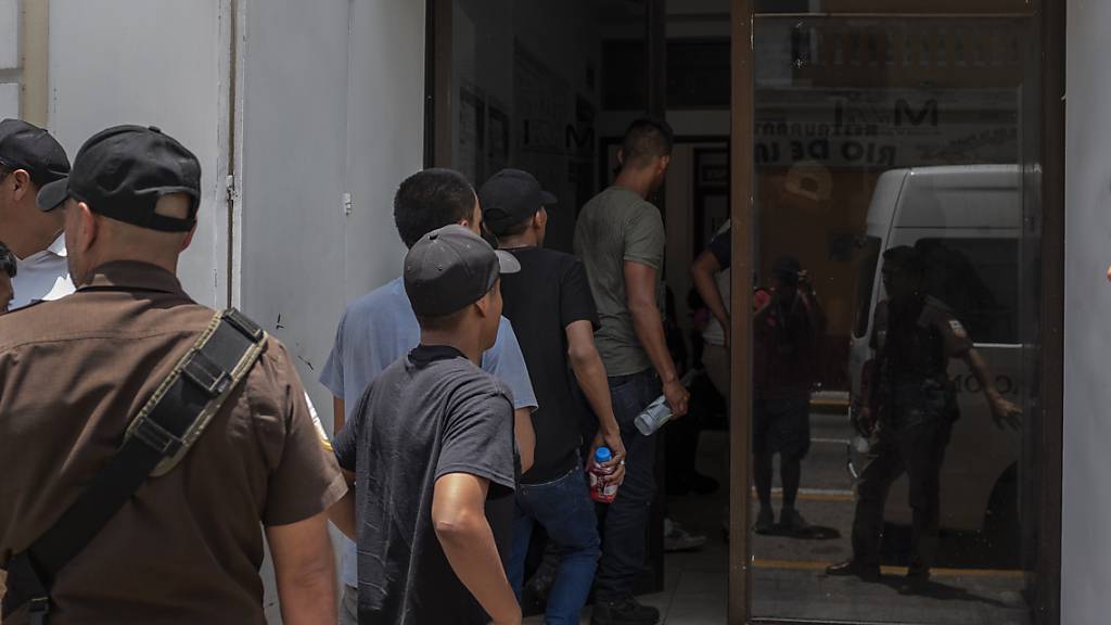 HANDOUT - Migranten, die aus einem abgestellten Lastwagen befreit wurden, werden in ein Büro des mexikanischen Instituts für Migration gebracht. Foto: Felix Marquez/dpa