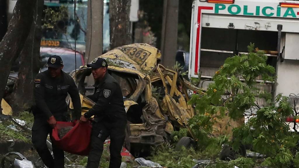 dpatopbilder - Die Polizei beseitigt die Trümmer einer Bombenexplosion. Foto: Santiago Saldarriaga/AP/dpa