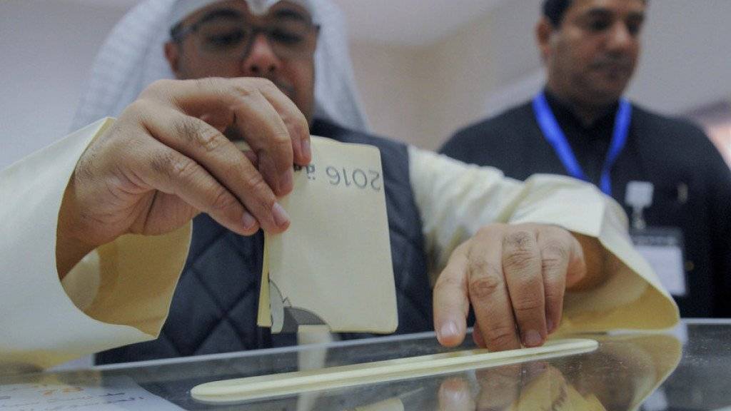 Ein Mann gibt in einem Wahllokal in Kuwait City bei der vorgezogenen Parlamentswahl seine Stimme ab.