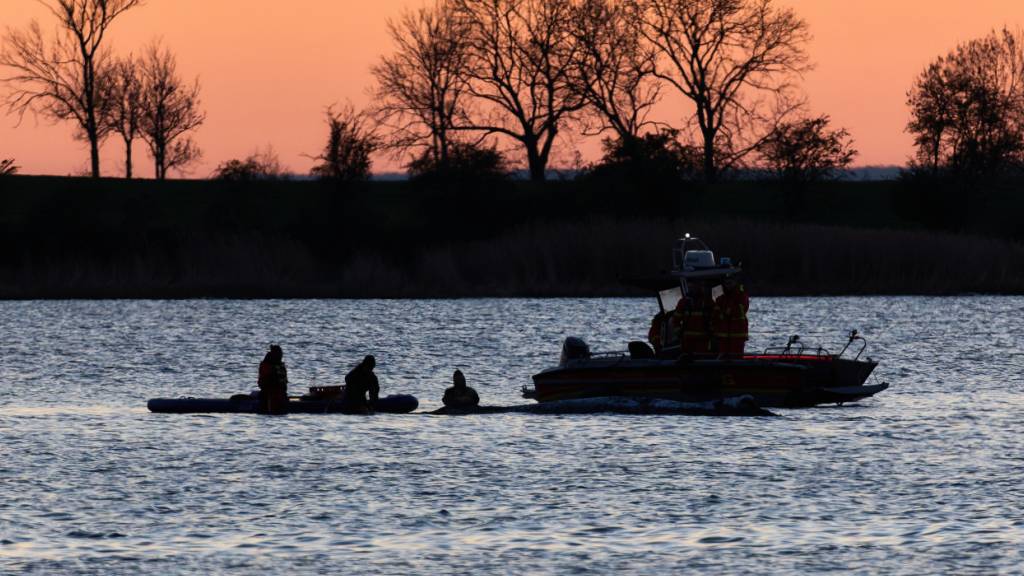 dpatopbilder - Helfer arbeiten in direkter Nähe des Wals. Der Buckelwal hat seine Position im flachen Wasser nicht wieder verlassen. Ein mehrköpfiges Team versucht den Wal wieder freizuspülen. Foto: Marcus Golejewski/dpa