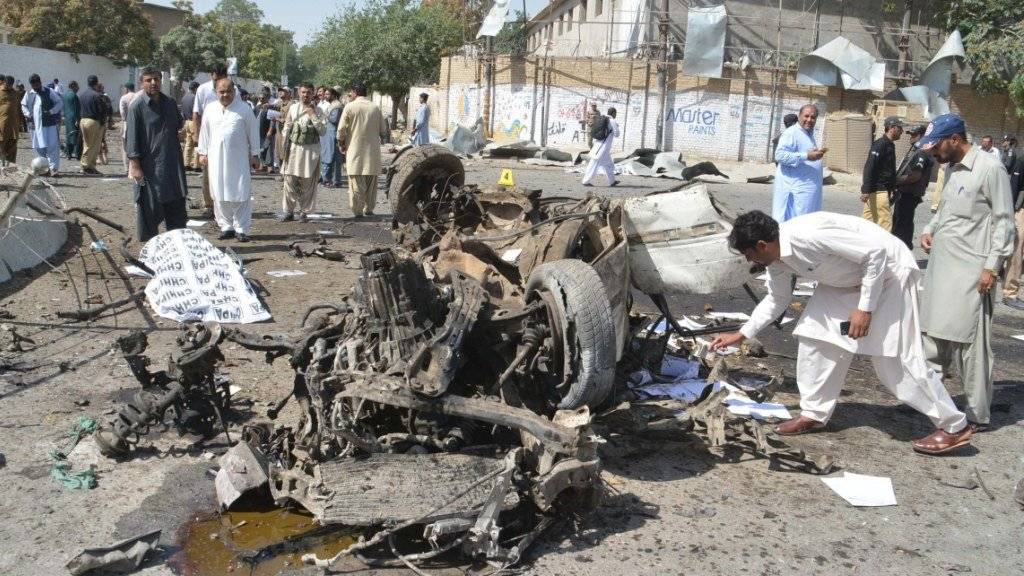 Pakistanische Sicherheitsverantwortliche untersuchen den Tatort eines Autobombenanschlags in der Provinzhauptstadt Quetta, bei dem mindestens 13 Menschen getötet wurden.