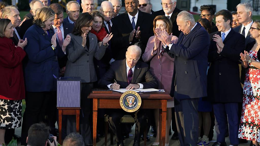 Joe Biden, Präsident der USA, unterzeichnet während einer Zeremonie auf dem South Lawn des Weißen Hauses das Infrastrukturgesetz. Foto: Evan Vucci/AP/dpa