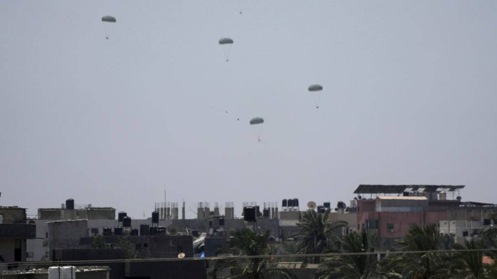 Aus Transportflugzeugen wird im zentralen Gazastreifen humanitäre Hilfe für Palästinenser abgeworfen und schwebt an Fallschirmen zu Boden. Foto: Abdel Kareem Hana/AP/dpa