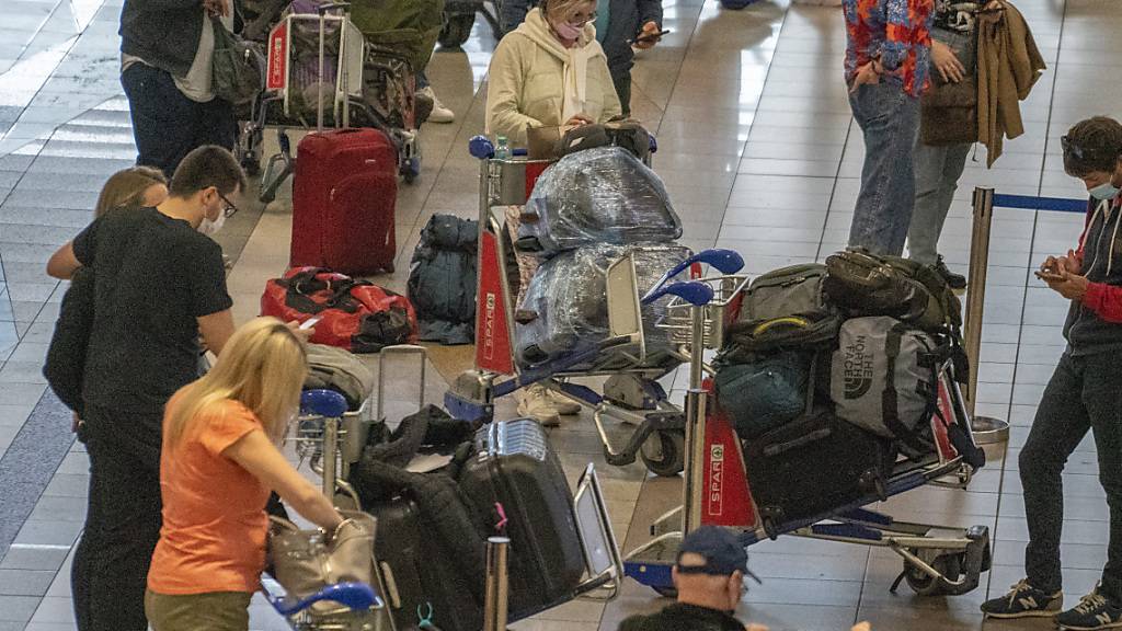 Menschen stellen sich auf dem Flughafen in Johannesburg für einen Air France-Flug nach Paris an. Die EU-Staaten wollen angesichts einer möglicherweise gefährlichen neuen Coronavirus-Variante die Passagierflüge aus sieben Ländern im südlichen Afrika aussetzen. Foto: Jerome Delay/AP/dpa