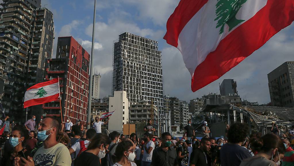 Regierungskritische Demonstranten nehmen an Demonstranten mit der Fahne des Libanon Mitte August bei einem Trauermarsch für die Opfer der verheerenden Explosion von Beirut.