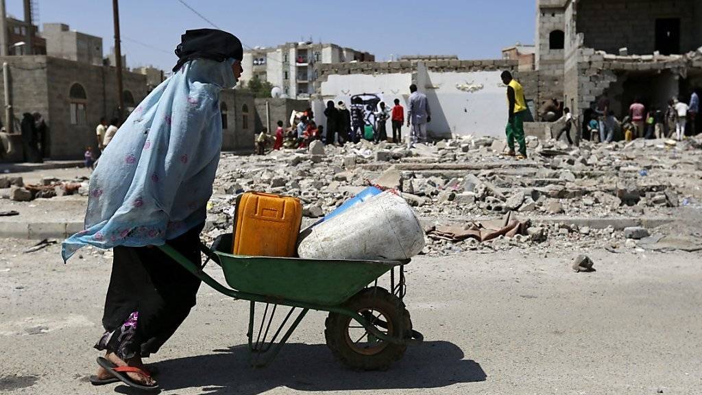 Eine jemenitische Frau holt Wasser in ihrer vom Bürgerkrieg zerstörten Stadt. Im Jemen kämpfen schiitische Houthi-Rebellen gegen Regierungstruppen, die von einer sunnitischen Koalition unter Führung Saudi-Arabiens unterstützt werden.