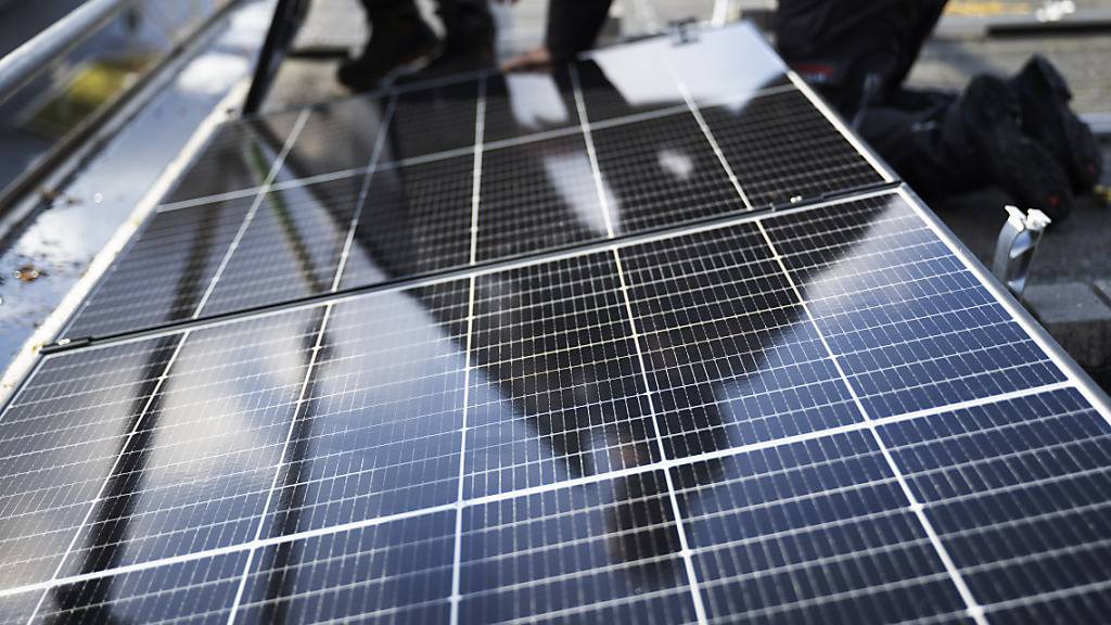 Montage einer Photovoltaik-Anlage auf einem Dach. Die Glarner Regierung will mit einer Klimastrategie die «Stossrichtung der Klimapolitik des Kantons festlegen». (Symbolbild)