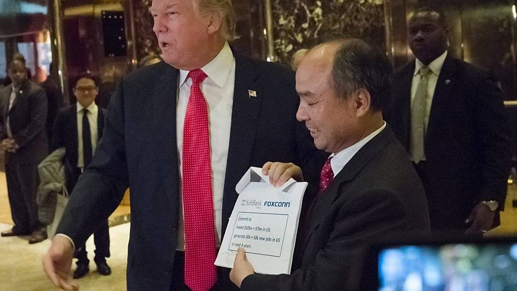 Der designierte US-Präsident Donald Trump und Softbank-Chef Son Masayoshi präsentieren den Medien im Trump Tower in New York den Deal über ein milliardenschweres Investitionsprogramm.