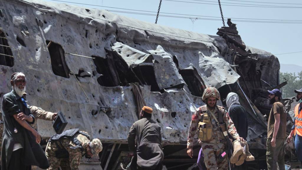 Sicherheitsbeamte untersuchen einen beschädigten Zugwaggon auf einem Bahngleis am Ort einer Bombenexplosion in Quetta. Foto: Arshad Butt/AP/dpa