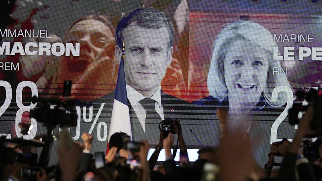 dpatopbilder - Ein Bildschirm zeigt den französischen Präsidenten Macron und die rechtsextreme Kandidatin Le Pen am Wahltag. Foto: Francois Mori/AP/dpa