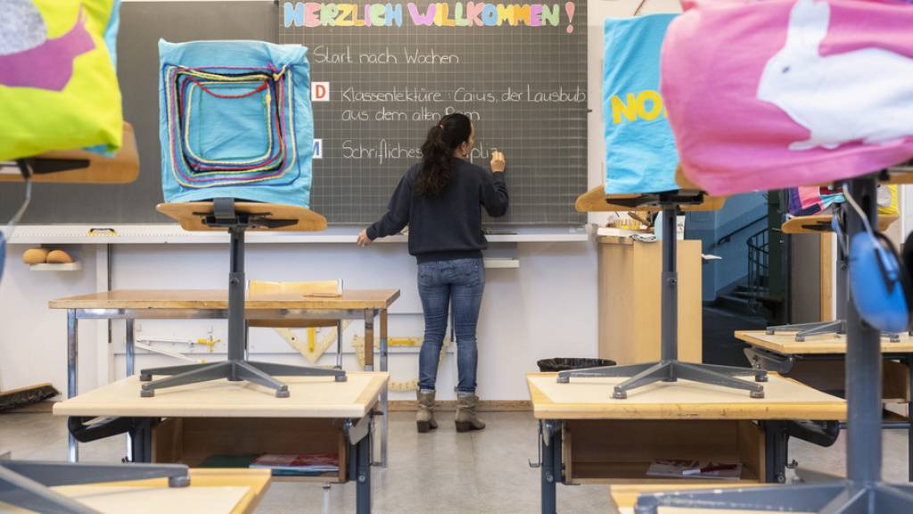 Lehrerin Simona Fischer schreibt am Montag - am ersten Schultag während der Corona-Pandemie - im Schulhaus Hutten in Zürich an der Wandtafel. Bei der Öffnung der obligatorischen Schulen herrscht föderalistischer Wildwuchs.