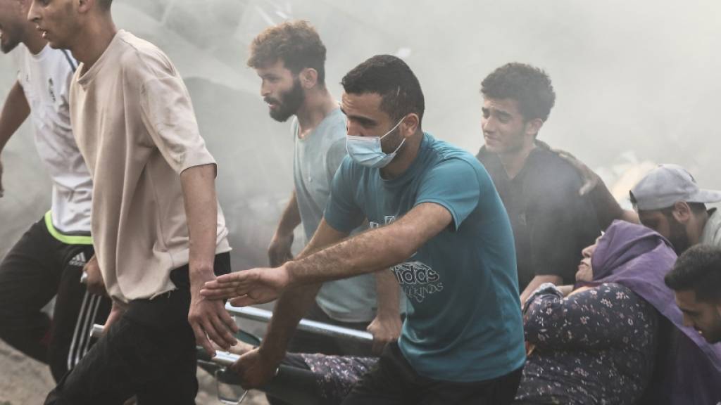 Nach einem israelischen Luftangriff auf Gaza-Stadt retten Palästinenser eine Frau aus den Trümmern eines zerstörten Gebäudes. Foto: Mohammed Abu Elsebah/dpa