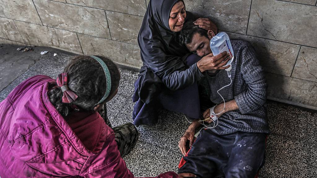 Eine Palästinenserin hält im Al-Najjar-Krankenhaus eine Glukoselösung für ihren Verwandten, der bei einem israelischen Luftangriff in der Nähe eines Lagerhauses des Hilfswerks der Vereinten Nationen für Palästinaflüchtlinge (UNRWA) verletzt wurde. Foto: Abed Rahim Khatib/dpa