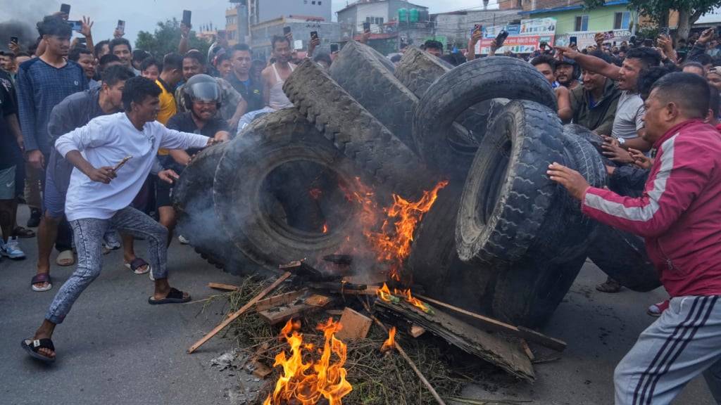 Demonstranten in Nepal verbrennen Reifen. Foto: Niranjan Shrestha/AP/dpa
