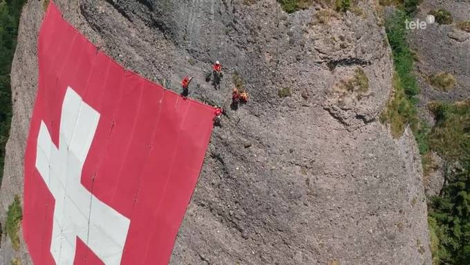 Sportler helfen bei Montage der Schweizer Fahne