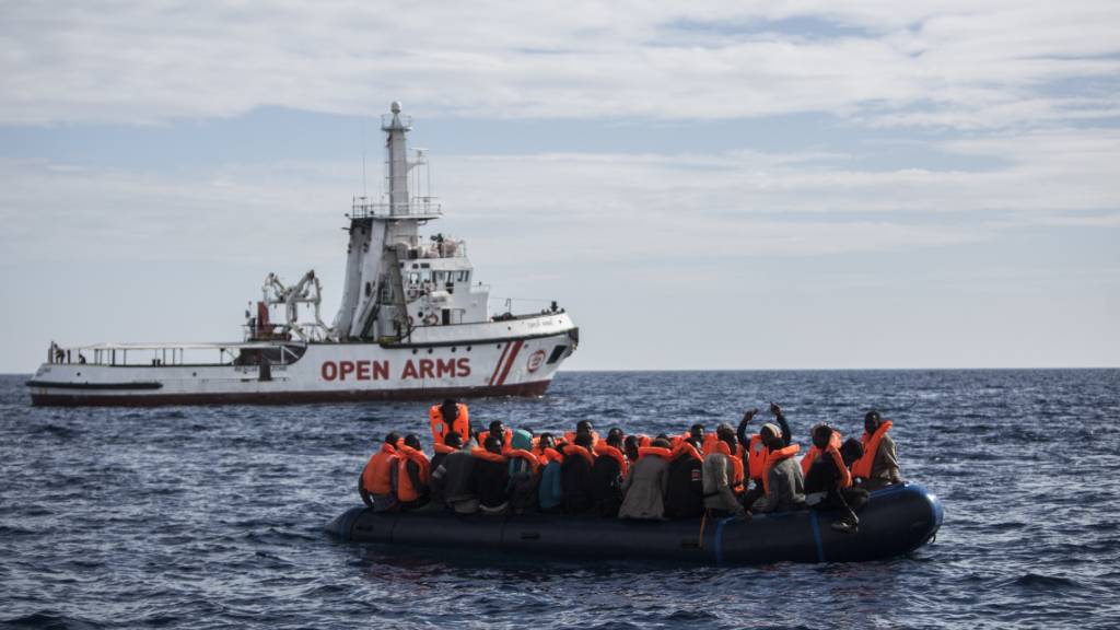 ARCHIV - Flüchtlinge die auf einem Schlauchboot im Mittelmeer treiben, freuen sich über die Ankunft eines Schiffes der spanischen Nichtregierungsorganisation «Pro Activa Open Arms». Foto: Javier Fergo/AP/dpa