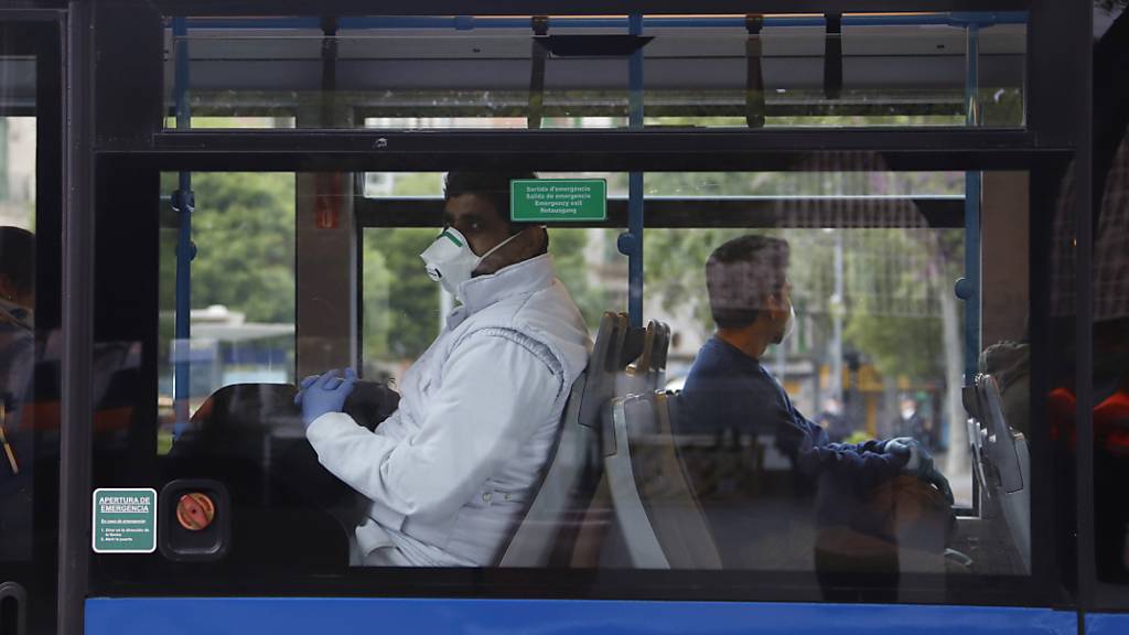 ARCHIV - Fahrgäste mit Mund-Nasen-Schutz sitzen am Bahnhof «Intermodal» in einem Bus. Zur Eindämmung von Corona-Infektionen sollen Fahrgäste in Bussen und Bahnen auf Mallorca und den anderen beliebten Ferieninseln der Balearen möglichst den Mund halten. Foto: Clara Margais/dpa