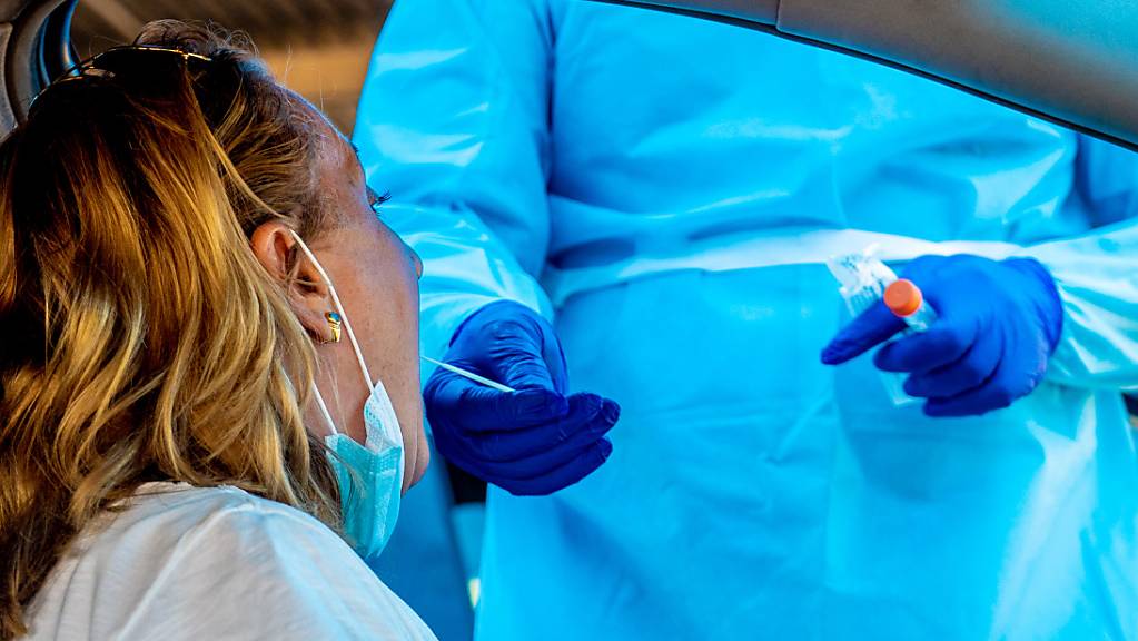 Ein Mitarbeiter des Gesundheitswesens nimmt bei einer Frau einen Abstrich in einer Drive-in Covid-19-Teststation in Sevilla. Foto: Eduardo Briones/EUROPA PRESS/dpa