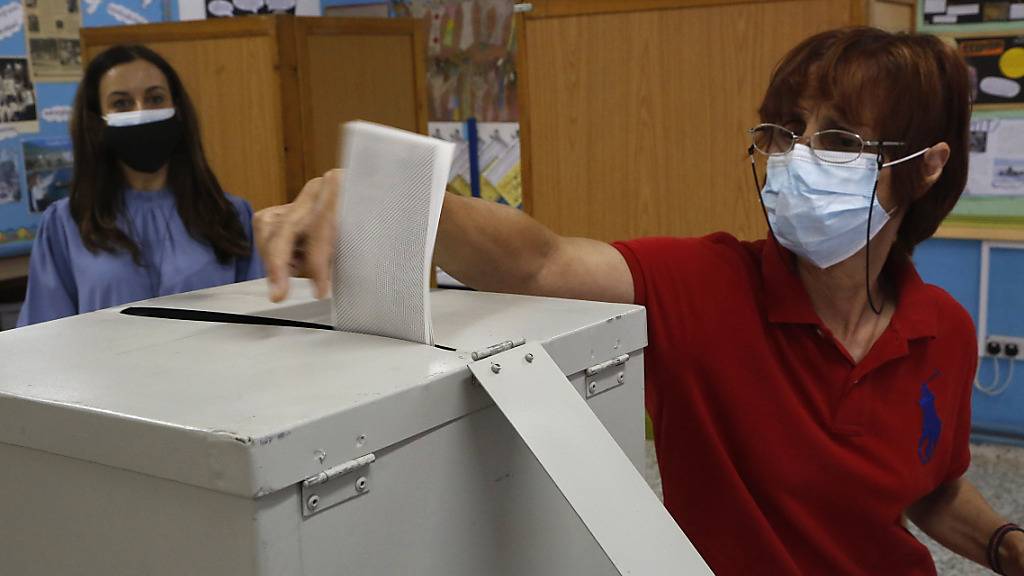 Eine Frau mit Mund-Nasen-Schutz gibt ihre Stimme in einem Wahllokal während der Parlamentswahlen ab. Foto: Petros Karadjias/AP/dpa