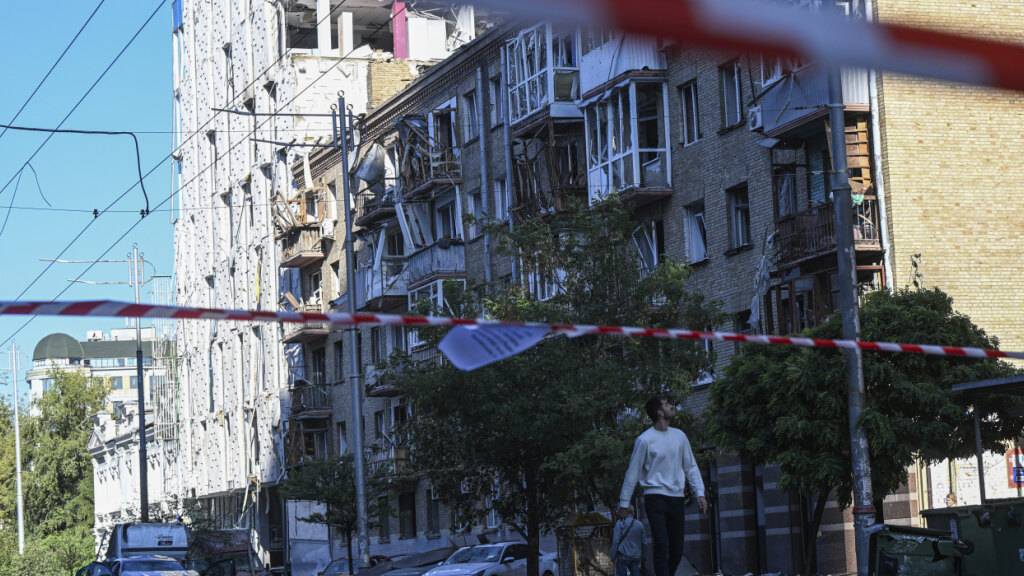Ein Mann geht an nach einem russischen Drohnen- und Raketenangriff beschädigten Wohnhäusern im Zentrum der Hauptstadt vorbei. Foto: Danylo Antoniuk/AP/dpa