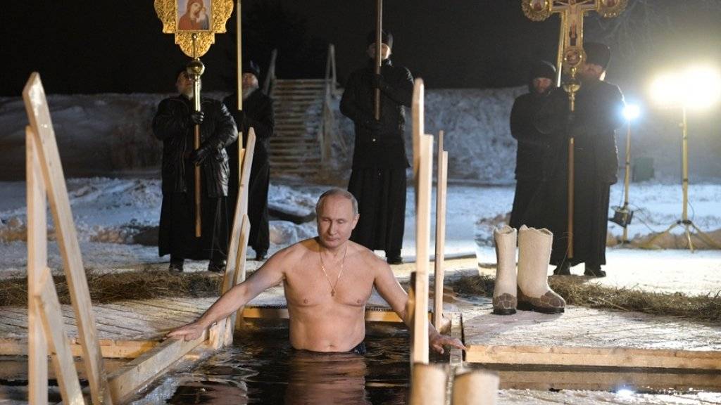 Aus Anlass des Epiphanias-Festes der orthodoxen Kirche: Der russische Präsident Wladimir Putin - umgeben von Popen und Ikonen - taucht bei minus fünf Grad Celsius in den Seliger-See nordwestlich von Moskau.