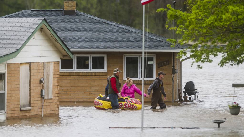 Einwohner in Beaverton im US-Staat Michigan bewegen sich nach Überschwemmungen auf Gummibooten vorwärts.