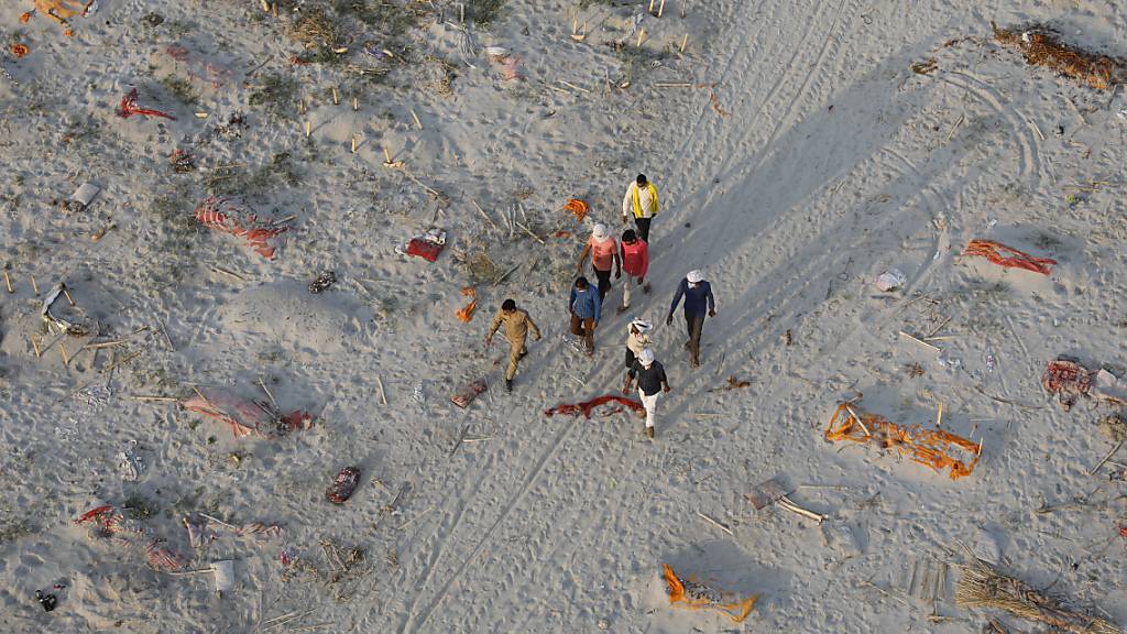 Leichen von mutmaßlichen Opfern des Coronavirus liegen in flachen Gräbern in einem Krematorium am Ufer des Ganges. Foto: Rajesh Kumar Singh/AP/dpa