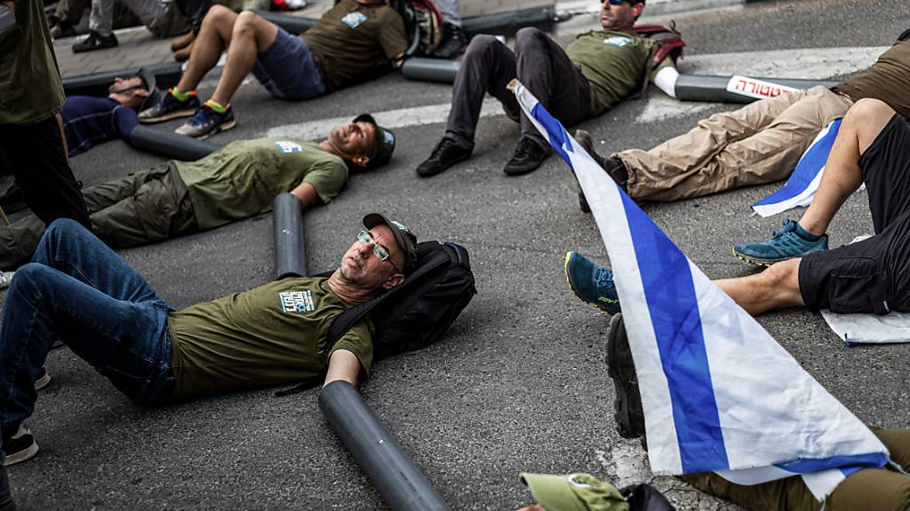Israelische Reservisten der Armee blockieren den Eingang zu einem Militärstützpunkt. Foto: Ilia Yefimovich/dpa