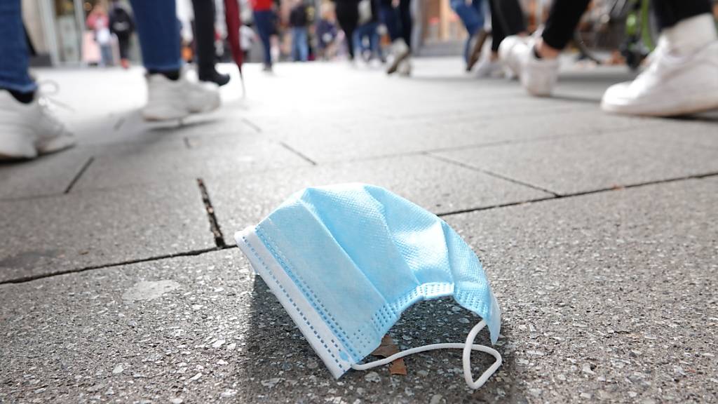 In der Fußgängerzone der Kölner Innenstadt gehen viele Menschen an einer auf dem Boden liegenden Mund-Nasen-Bedeckung vorbei. .Erstmals seit April wurden in Deutschland mehr als 5000 neue Corona-Infektionen innerhalb eines Tages gemeldet. Foto: Weronika Peneshko/dpa