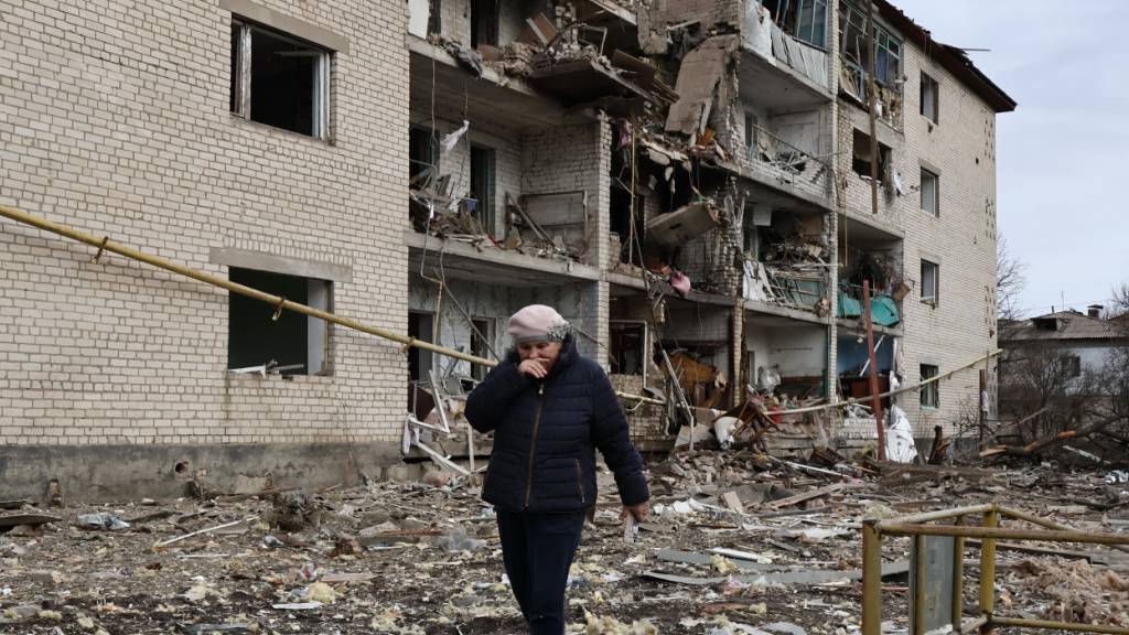HANDOUT - Auf diesem vom Pressedienst der 65. Mechanisierten Brigade der Ukraine zur Verfügung gestellten Foto geht eine Einheimische an einem zerstörten Wohnhaus vorbei, das nach einem russischen Luftangriff in der Region Saporischschja zerstört wurde. Foto: Andriy Andriyenko/Ukrainian 65 Mechanized brigade via AP/dpa - ACHTUNG: Nur zur redaktionellen Verwendung und nur mit vollständiger Nennung des vorstehenden Credits