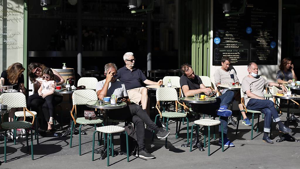 Gäste sitzen auf der Terrasse einer Gastronomie in Paris. Mit dem Ende der strengen Ausgangsbeschränkungen wird in Paris die Luft wieder schlechter. Foto: Thibault Camus/AP/dpa