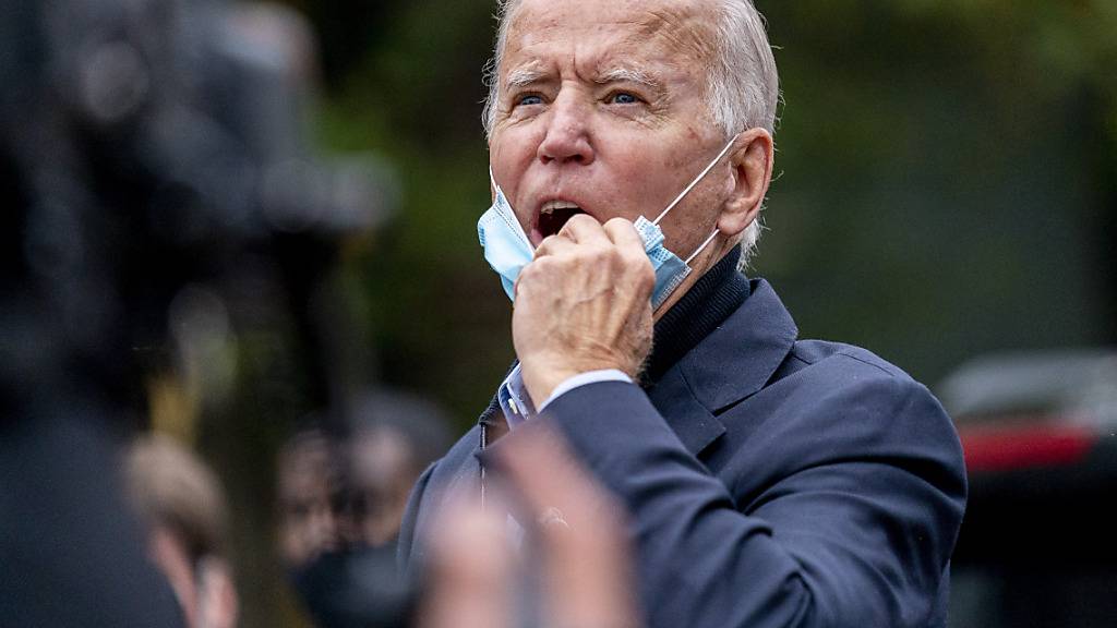 Joe Biden, demokratischer Präsidentschaftskandidat und ehemaliger Vizepräsident, ruft Menschen zu, die ihn aus einem Fenster im zweiten Stock betrachten, während er ein Wähler-Service-Center besucht. Foto: Andrew Harnik/AP/dpa