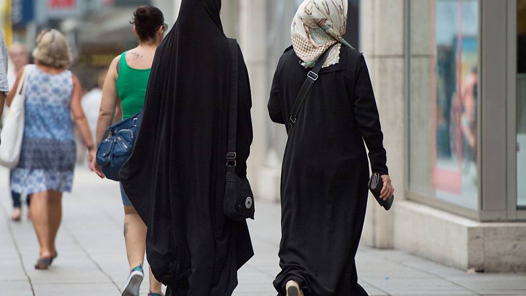 ARCHIV - Zwei Frauen mit Kopftuch und langer Oberbekleidung gehen eine Straße entlang. Foto: Marijan Murat/dpa