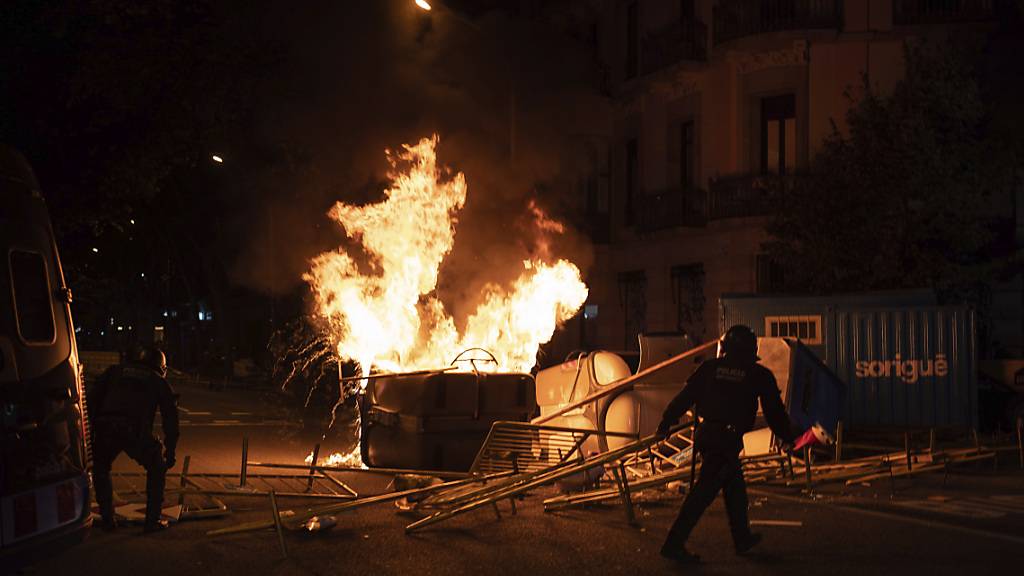 Polizisten entfernen Barrikaden während einer Kundgebung gegen die Enthebung des katalanischen Regionalpräsidenten Torra. Foto: Felipe Dana/AP/dpa