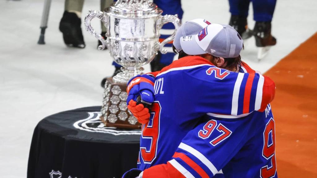 Connor McDavid (Nr. 97) und Leon Draisaitl vor der Trophäe, die sie schon gewonnen haben -  dem Pokal für den Gewinn der Western Conference