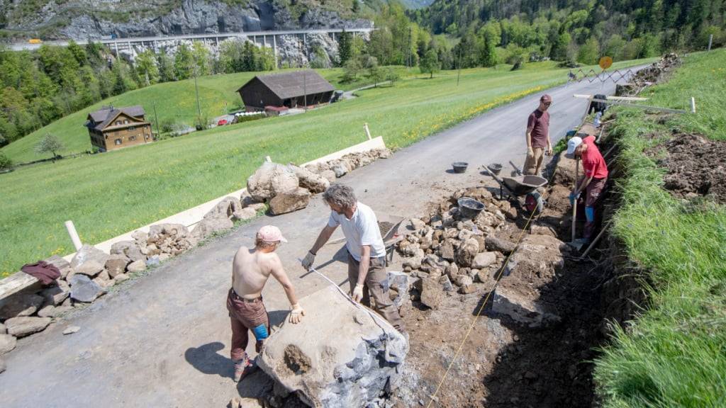 Zivis arbeiten am Bau einer Trockenmauer entlang einer Strasse im Muotathal SZ. (Archivbild)