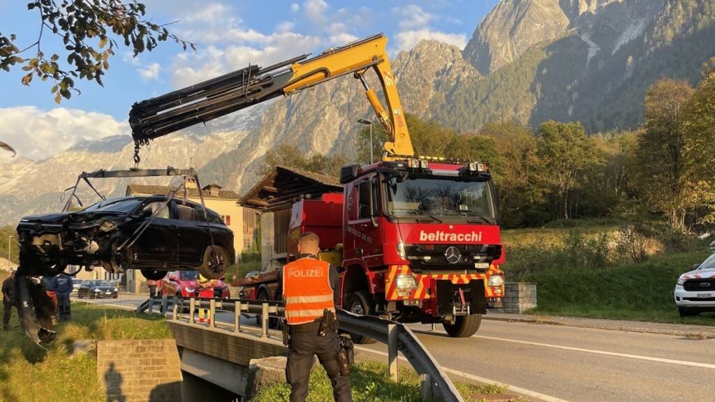 Ein Autokran hebt den verunfallten Wagen aus dem Bachkanal.