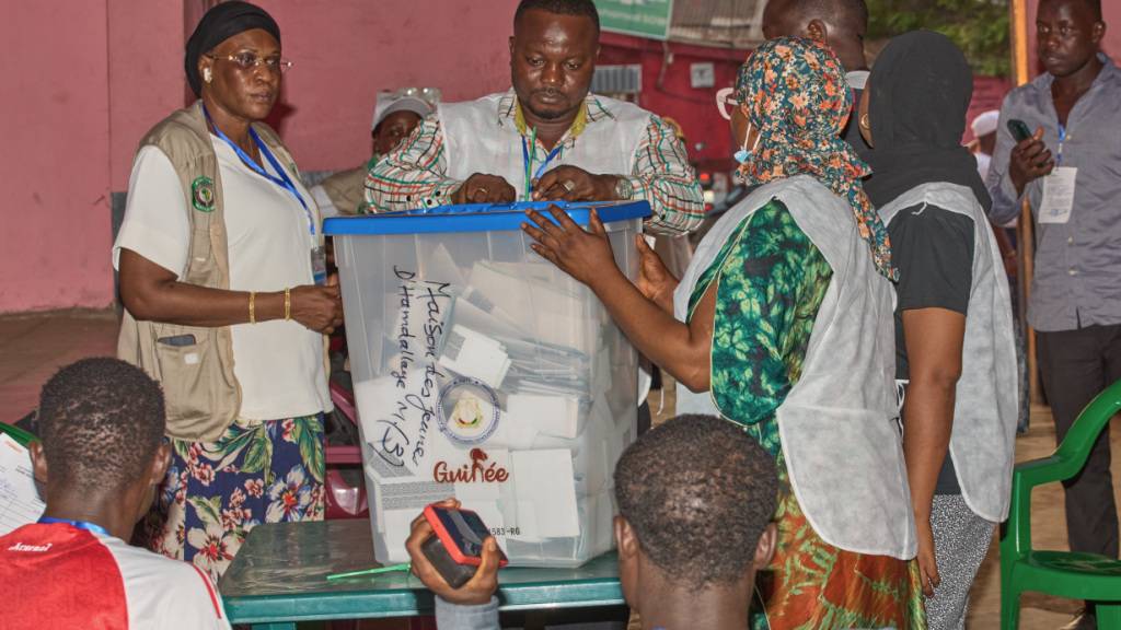 Beamte bereiten sich auf die Auszählung der Stimmzettel in einem Wahllokal vor, als die Wahllokale während der Präsidentschaftswahlen schließen. Foto: Fode Toure/AP/dpa