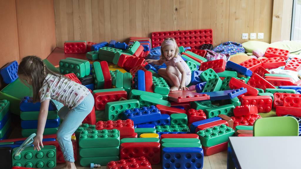 Kinder haben Spass beim Bauen mit farbigen und grossen Legosteinen.