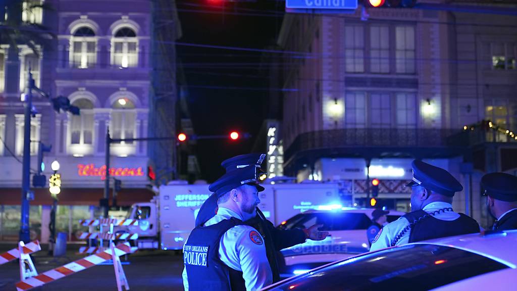 Polizeibeamte stehen in der Nähe des Tatorts, an dem ein Fahrzeug in eine Menschenmenge auf der Canal und Bourbon Street gefahren wurde. Foto: George Walker IV/AP/dpa