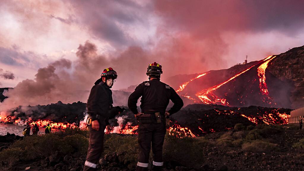 Mitglieder der militärischen Notfalleinheit (UME) sind im Einsatz, als Lava aus einem Vulkan ins Meer fließt. Auf der Kanareninsel La Palma spuckt seit neun Wochen der Vulkan Lava, Asche und Rauch aus. Ein Ende des verheerenden Ausbruchs ist immer noch nicht absehbar.